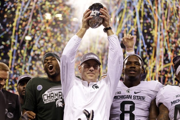 Michigan State coach Mark Dantonio holds the trophy after Michigan State defeated Iowa 16-13 in the Big Ten championship NCAA college football game Saturday, Dec. 5, 2015, in Indianapolis. (AP Photo/Michael Conroy)