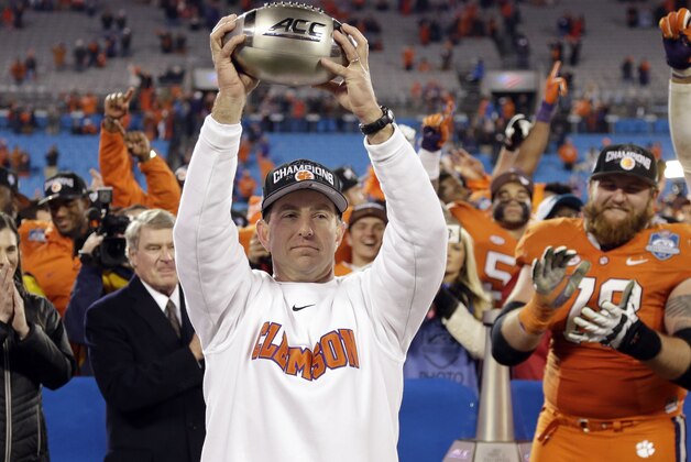 Clemson coach Dabo Swinney holds the championship trophy after Clemson defeated North Carolina in the Atlantic Coast Conference championship NCAA college football game in Charlotte, N.C., early Sunday, Dec. 6, 2015. Clemson won 45-37. (AP Photo/Bob Leverone)