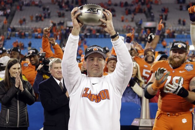 Clemson coach Dabo Swinney holds the championship trophy after Clemson defeated North Carolina in the Atlantic Coast Conference championship NCAA college football game in Charlotte, N.C., early Sunday, Dec. 6, 2015. Clemson won 45-37. (AP Photo/Bob Leverone)