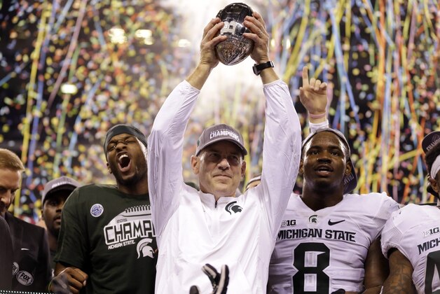 Michigan State coach Mark Dantonio holds the trophy after Michigan State defeated Iowa 16-13 in the Big Ten championship NCAA college football game Saturday, Dec. 5, 2015, in Indianapolis. (AP Photo/Michael Conroy)