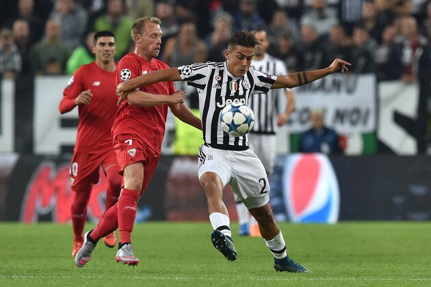TURIN, ITALY - SEPTEMBER 30:  Paulo Dybala (R) of Juventus is challenged by Michael Krohn-Dehli of Sevilla during the UEFA Champions League group E match between Juventus and Sevilla FC on September 30, 2015 in Turin, Italy.  (Photo by Valerio Pennicino/Getty Images)