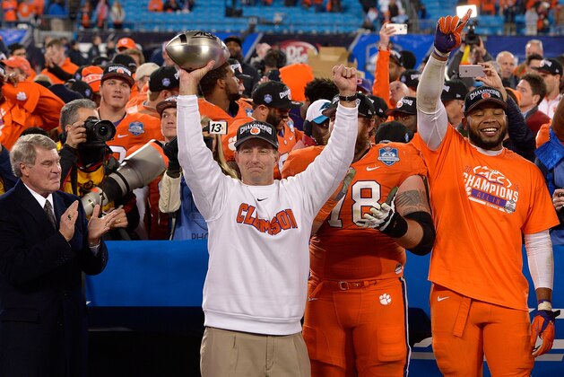 CHARLOTTE, NC - DECEMBER 05:  Head coach Dabo Swinney of the Clemson Tigers celebrates with the trophy after a win against the North Carolina Tar Heels during the Atlantic Coast Conference Football Championship at Bank of America Stadium on December 5, 2015 in Charlotte, North Carolina. Clemson won 45-37.  (Photo by Grant Halverson/Getty Images)