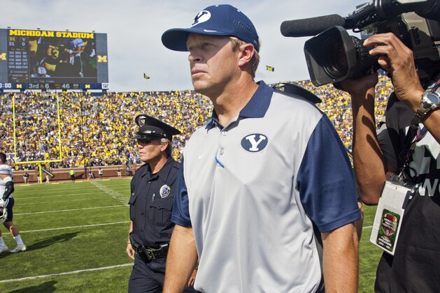 BYU head coach Bronco Mendenhall walks on the field for the post game hand shake after an NCAA college football game against Michigan in Ann Arbor, Mich., Saturday, Sept. 26, 2015. Michigan won 31-0. (AP Photo/Tony Ding)