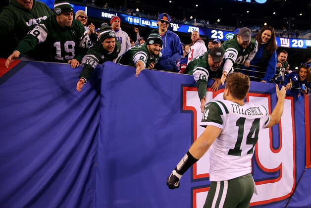 EAST RUTHERFORD, NJ - DECEMBER 06:   Ryan Fitzpatrick #14 of the New York Jets celebrates the win with fans after the game against the New York Giants on December 6, 2015 at MetLife Stadium in East Rutherford, New Jersey.The New York Jets defeated the New York Giants 23-20 in overtime.  (Photo by Elsa/Getty Images)