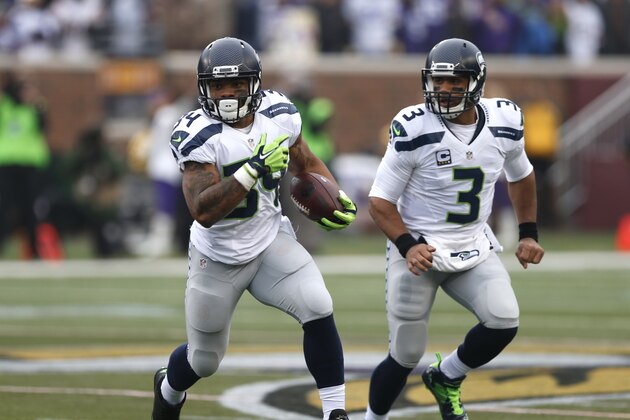Seattle Seahawks running back Thomas Rawls (34) runs with the ball as quarterback Russell Wilson (3) looks on against the Minnesota Vikings in the first half of an NFL football game Sunday, Dec. 6, 2015 in Minneapolis. (AP Photo/Jim Mone)