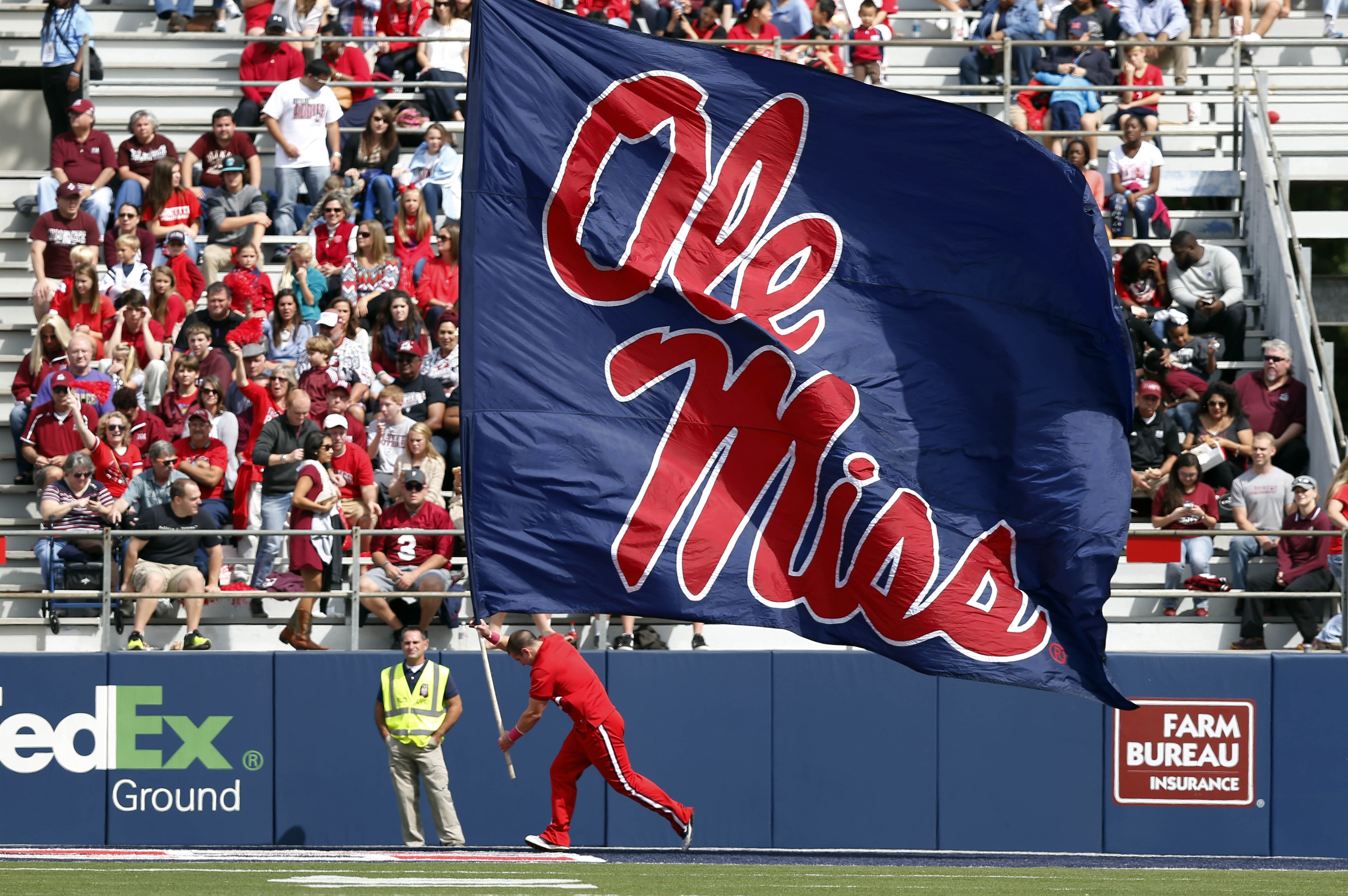 A Mississippi cheerleader runs along the end zone with an oversized Ole Miss flag following a score in the second half of an NCAA college football game in Oxford, Miss., Saturday, Oct. 10, 2015. No. 14 Mississippi won 52-3. (AP Photo/Rogelio V. Solis)
