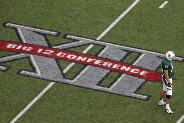 FILE - In this Oct. 13, 2012, file photo, Baylor's Matt Ritchey (45) stands by the Big 12 Conference logo painted on the field during an NCAA college football game against TCU in Waco, Texas. The ACC and the Big 12 are in the process of trying to change NCAA rules regarding conference championship games. Currently, a conference must have at least 12 teams, split into two divisions and all the teams in that division must play each other. (AP Photo/Tony Gutierrez, File)