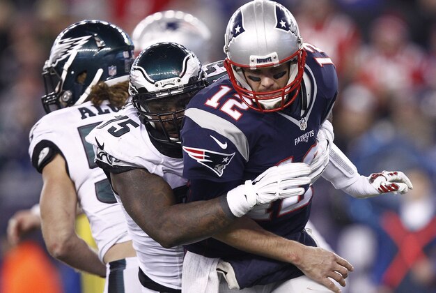 Dec 6, 2015; Foxborough, MA, USA; New England Patriots quarterback Tom Brady (12) is tackled by Philadelphia Eagles defensive end Vinny Curry (back) during the second half at Gillette Stadium. Mandatory Credit: Mark L. Baer-USA TODAY Sports