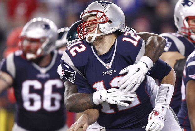 Dec 6, 2015; Foxborough, MA, USA; New England Patriots quarterback Tom Brady (12) is tackled by Philadelphia Eagles defensive end Vinny Curry (back) during the second half at Gillette Stadium. Mandatory Credit: Mark L. Baer-USA TODAY Sports