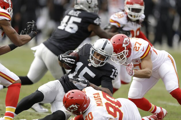 Oakland Raiders wide receiver Michael Crabtree (15) is tackled by Kansas City Chiefs inside linebacker Josh Mauga (90) and defensive back Tyvon Branch (27) during the first half of an NFL football game in Oakland, Calif., Sunday, Dec. 6, 2015. (AP Photo/Ben Margot)