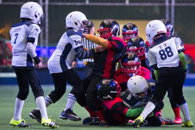 Chinese youths take part in a Youth Tackle Football game at a National Football League publicity event held in Beijing, China, Friday, Oct. 23, 2015. The NFL has been aggressively promoting football in China hoping to take advantage of rising income and growing taste for exotic foreign sports.  (AP Photo/Ng Han Guan)