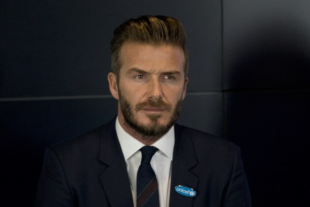 Former English national soccer team captain David Beckham watches a video clip being played on a big screen during a press conference to mark his 10 years as a goodwill ambassador for UNICEF and to launch '7' a new fund for children in danger across the globe in London, Monday, Feb. 9, 2015.  (AP Photo/Matt Dunham)