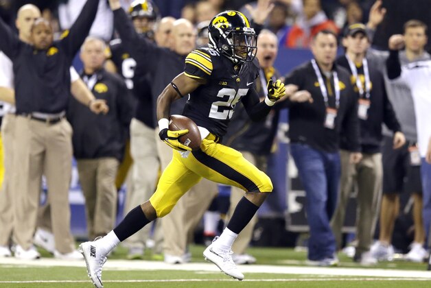 Iowa running back Akrum Wadley (25) rushes for a gain against Michigan State during the first half of the Big Ten Conference championship NCAA college football game Saturday, Dec. 5, 2015, in Indianapolis. (AP Photo/Michael Conroy)