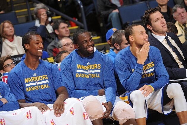 OAKLAND, CA - DECEMBER 30: Harrison Barnes #40, Draymond Green #23 and Stephen Curry #30 of the Golden State Warriors rest on the bench against the Philadelphia 76ers on December 30, 2014 at Oracle Arena in Oakland, California. NOTE TO USER: User expressly acknowledges and agrees that, by downloading and or using this photograph, user is consenting to the terms and conditions of Getty Images License Agreement. Mandatory Copyright Notice: Copyright 2014 NBAE (Photo by Noah Graham/NBAE via Getty Images)