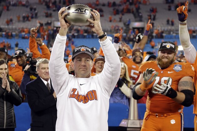 Clemson coach Dabo Swinney holds the championship trophy after Clemson defeated North Carolina in the Atlantic Coast Conference championship NCAA college football game in Charlotte, N.C., early Sunday, Dec. 6, 2015. Clemson won 45-37. (AP Photo/Bob Leverone)