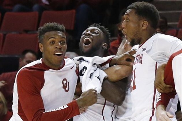 Oklahoma guard Buddy Hield, left, forward Khadeem Lattin, center, and forward Dante Buford, right, react following a dunk by a teammate during the second half of an NCAA college basketball game against Incarnate Word in Norman, Okla., Tuesday, Nov. 24, 2015. Oklahoma won 96-63. (AP Photo/Sue Ogrocki)