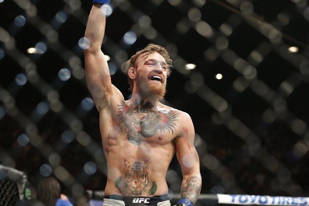 Conor McGregor celebrates between rounds against Chad Mendes during their interim featherweight title mixed martial arts bout at UFC 189 on Saturday, July 11, 2015, in Las Vegas. (AP Photo/John Locher)