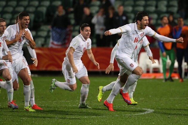 Marko Grujic of Serbia (R) leads teammates as they celebrate their victory during a penalty shootout during the FIFA U20 World Cup quarter-final match between the USA and Serbia in Auckland on June 14, 2015.     AFP PHOTO / Fiona GOODALL        (Photo credit should read Fiona GOODALL/AFP/Getty Images)