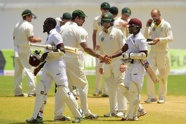 Australia's Mitchell Johnson (center L) shakes hands with West Indies batsman Veerasammy Permaul (2R) after Australia defeated the West Indies by 277 runs to win the second cricket Test at Sabina Park in Kingston, Jamaica on June 14, 2015.  Australia won the test series 2-0.    AFP PHOTO / ROBYN BECK        (Photo credit should read ROBYN BECK/AFP/Getty Images)