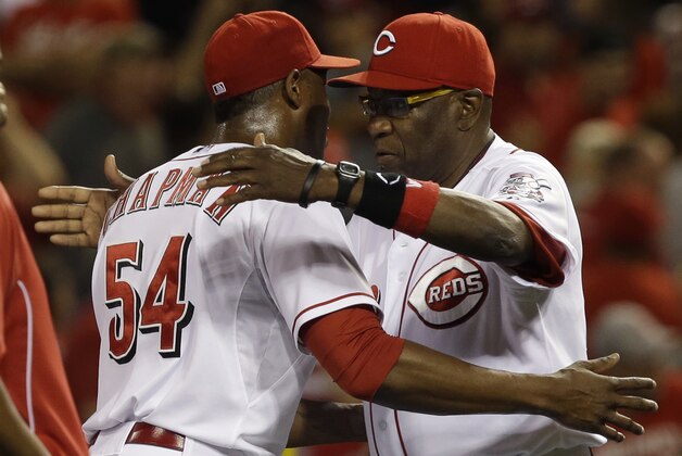 Cincinnati Reds' Dusty Baker hugs relief pitcher Aroldis Chapman (54) after they defeated the St. Louis Cardinals 8-3 in a baseball game, Saturday, Aug. 3, 2013, in Cincinnati. (AP Photo/Al Behrman)