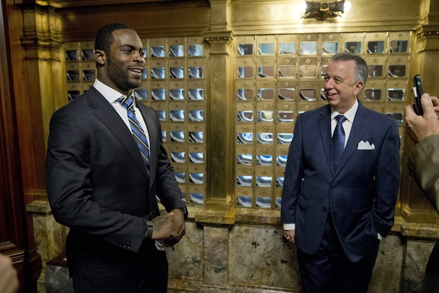 Rep. Joe Markosek D-Allegheny, right, looks on as Pittsburgh Steelers quarterback Michael Vick poses for a photograph Tuesday, Dec. 8, 2015, at the state Capitol in Harrisburg, Pa. Vick is lobbing Pennsylvania legislators on a bill that would help protect pets left in hot cars. Vick was a star quarterback for the NFL's Atlanta Falcons when he pleaded guilty in 2007 to being part of a dogfighting ring and ended up serving 21 months in prison. (AP Photo/Matt Rourke)
