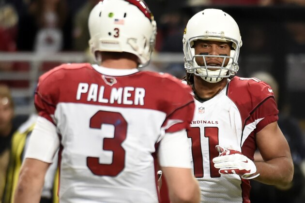 Arizona Cardinals wide receiver Larry Fitzgerald, right, is congratulated by quarterback Carson Palmer after catching a pass during the fourth quarter of an NFL football game against the St. Louis Ram on Sunday, Dec. 6, 2015, in St. Louis. With the reception, Fitzgerald has surpassed Andre Johnson as the youngest player to reach 1,000 career receptions in NFL history. (AP Photo/L.G. Patterson)