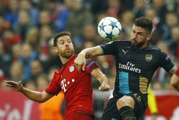 Bayern's Xabi Alonso, left, and Arsenal's Olivier Giroud challenge for the ball during the Champions League Group F soccer match between Bayern Munich and Arsenal FC in Munich, southern Germany, Wednesday, Nov. 4, 2015. (AP Photo/Matthias Schrader)