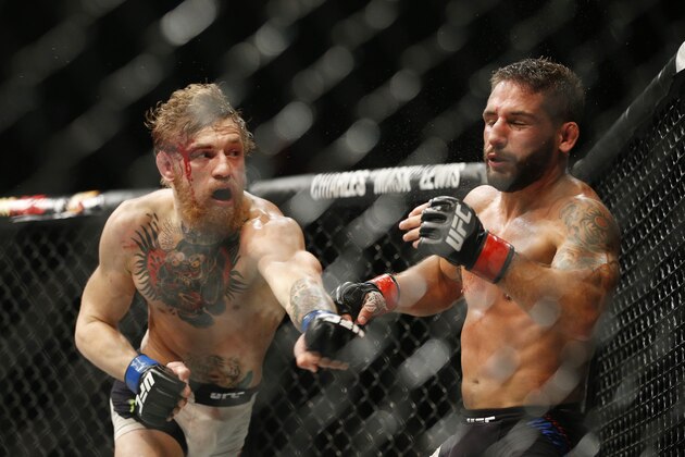 Conor McGregor lands a left to Chad Mendes to end their interim featherweight title mixed martial arts bout at UFC 189 on Saturday, July 11, 2015, in Las Vegas. (AP Photo/John Locher)