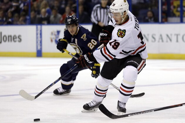 Chicago Blackhawks' Jonathan Toews (19) passes the puck as St. Louis Blues' Alexander Steen watches during the first period of an NHL hockey game, Saturday, Nov. 14, 2015, in St. Louis. (AP Photo/Jeff Roberson)