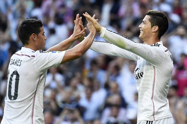 Real Madrid's Portuguese forward Cristiano Ronaldo (R) celebrates with Real Madrid's Colombian midfielder James Rodriguez (L) after scoring during the Spanish league 'Clasico' football match Real Madrid CF vs FC Barcelona at the Santiago Bernabeu stadium in Madrid on October 25, 2014. AFP PHOTO/ GERARD JULIEN        (Photo credit should read GERARD JULIEN/AFP/Getty Images)