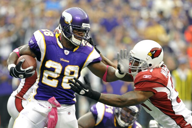 Minnesota Vikings running back Adrian Peterson (28) tries to break a tackle by Arizona Cardinals cornerback Richard Marshall, right, during the first half of an NFL football game on Sunday, Oct. 9, 2011, in Minneapolis. (AP Photo/Jim Mone)