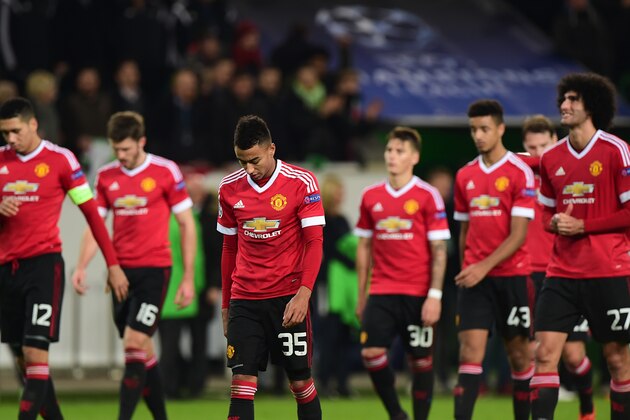 TOPSHOT - Manchester United's players look dejected as they leave the pitch after the UEFA Champions League Group B second-leg football match VfL Wolfsburg vs Manchester United in Wolfsburg, central Germany, on December 8, 2015.  / AFP / JOHN MACDOUGALL        (Photo credit should read JOHN MACDOUGALL/AFP/Getty Images)