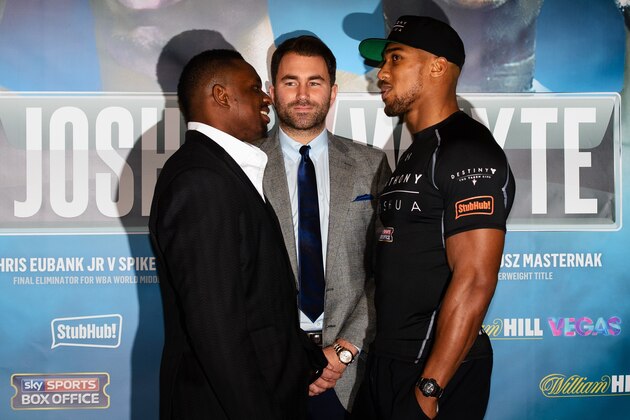 British boxer Anthony Joshua (R) and his opponent British boxer Dillian Whyte (L) flank promoter Eddie Hearn (C) as they pose for a photograph following a press conference in east London on December 10, 2015 to promote their British and Commonwealth heavyweight title fight on December 12. AFP PHOTO / LEON NEAL / AFP / LEON NEAL        (Photo credit should read LEON NEAL/AFP/Getty Images)