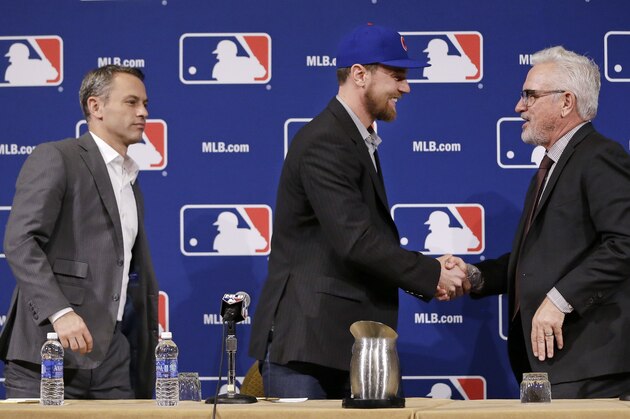 Switch-hitting free agent Ben Zobrist, center, shakes hands with Chicago Cubs manager Joe Maddon, right, at Major League Baseball's winter meetings where it was announced that Zobrist has signed with the Cubs Wednesday, Dec. 9, 2015, in Nashville, Tenn. At left is Cubs general manager Jed Hoyer. (AP Photo/Mark Humphrey)