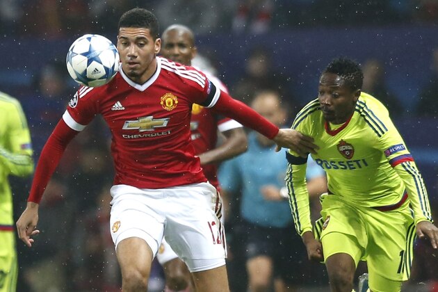 Manchester United's Chris Smalling, left, fights for the ball with CSKA's Ahmed Musa during the Champions League Group B soccer match between Manchester United and CSKA Moskva at Old Trafford Stadium, Manchester, England, Tuesday, Nov. 3, 2015. (AP Photo/Jon Super)