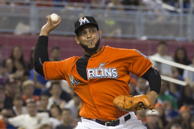 Miami Marlins starting pitcher Henderson Alvarez tries to make a play at first base after being hit by and then dropping the ball during the second inning of a baseball game against the Atlanta Braves in Miami, Sunday, May 17, 2015. (AP Photo/J Pat Carter)
