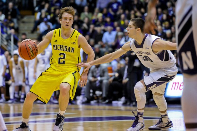 Northwestern guard Bryant McIntosh (30)  guards against Michigan guard Spike Albrecht (2) during an NCAA college basketball game on Tuesday, March 3, 2015, in Evanston, Ill. Northwestern won 82-78 in double overtime. (AP Photo/Matt Marton)