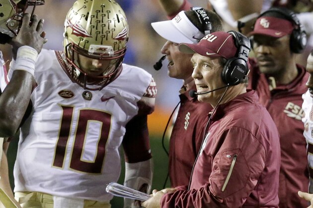 Florida State head coach Jimbo Fisher, center talks with quarterback Sean Maguire (10) during a timeout in the first half of an NCAA college football game against Florida, Saturday, Nov. 28, 2015, in Gainesville, Fla. (AP Photo/John Raoux)