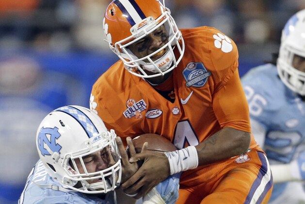 Clemson quarterback Deshaun Watson (4) runs the ball as North Carolina's Mikey Bart (45) tackles during the second half of the Atlantic Coast Conference championship NCAA college football game in Charlotte, N.C., Saturday, Dec. 5, 2015. (AP Photo/Bob Leverone)