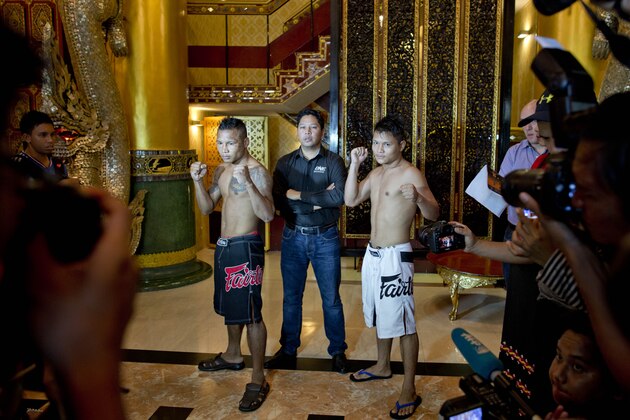 In this Friday, July 17, 2015, photo, Hlit Hlit Lay, right, a member of the White New Blood lethwei fighters club, a Myanmar traditional martial-arts club which practices a rough form of kickboxing, poses with opponent Tha Pyay Nyo, left and