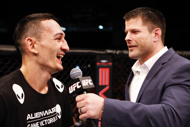 SINGAPORE - JANUARY 04:  (L-R) Max Holloway has a laugh with Brian Stann after his win over Will Chope in their featherweight bout during the UFC Fight Night event at the Marina Bay Sands Resort on January 4, 2014 in Singapore. (Photo by Mitch Viquez/Zuffa LLC/Zuffa LLC via Getty Images)