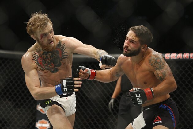 Conor McGregor, left, fights Chad Mendes during their interim featherweight title mixed martial arts bout at UFC 189 Saturday, July 11, 2015, in Las Vegas. (AP Photo/John Locher)