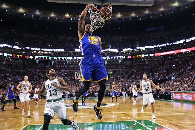 Golden State Warriors forward Andre Iguodala (9) slams a dunk over Boston Celtics guard James Young (13) during the first quarter of an NBA basketball game in Boston, Friday, Dec. 11, 2015. (AP Photo/Charles Krupa)