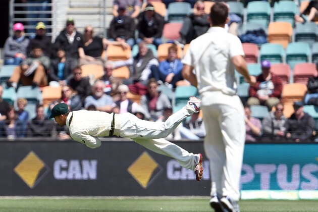 Australian paceman James Pattinson (L) dives as he attempts to take a catch from the West Indies batsman as teammate Josh Hazlewood (R) looks on during the third day of the first cricket Test match in Hobart on December 12, 2015.   AFP PHOTO / William WEST   --IMAGE RESTRICTED TO EDITORIAL USE - NO COMMERCIAL USE-- / AFP / WILLIAM WEST        (Photo credit should read WILLIAM WEST/AFP/Getty Images)