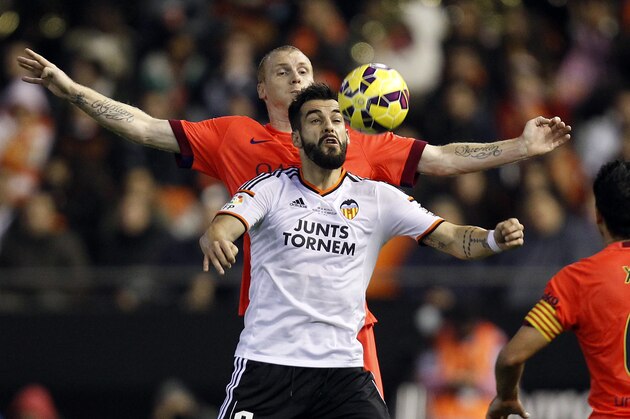 Barcelona's Jeremy Matieu from France, rear, duels for the ball with Valencia's Alvaro Negredo during a Spanish La Liga soccer match at the Mestalla stadium in Valencia, Spain, on Sunday, Nov. 30, 2014.(AP Photo/Alberto Saiz)
