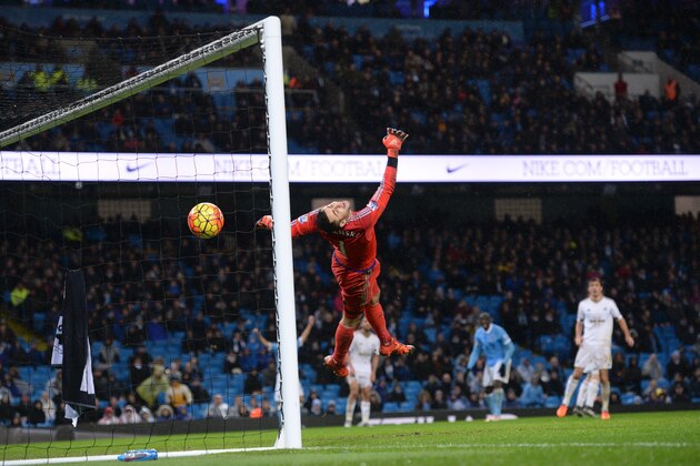 Swansea City's Polish goalkeeper Lukasz Fabianski dives in vain as he fails to stop a deflected shot from Manchester City's Ivorian midfielder and captain Yaya Toure for City's second goal during the English Premier League football match between Manchester City and Swansea City at the Etihad Stadium in Manchester, north west England, on December 12, 2015. AFP PHOTO / OLI SCARFF

RESTRICTED TO EDITORIAL USE. No use with unauthorized audio, video, data, fixture lists, club/league logos or 'live' services. Online in-match use limited to 75 images, no video emulation. No use in betting, games or single club/league/player publications. / AFP / OLI SCARFF        (Photo credit should read OLI SCARFF/AFP/Getty Images)