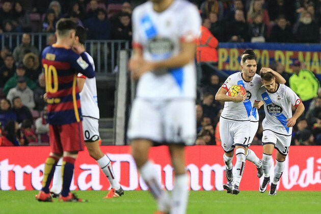 Deportivo de La Coruna's Spanish midfielder Lucas Perez (2nd R) holds the ball after scoring a goal as he celebrates with teammate Deportivo La Coruna's Portuguese midfielder Cardoso (R) during the Spanish league football match FC Barcelona vs Deportivo de La Coruna at the Camp Nou stadium in Barcelona on December 12, 2015. AFP PHOTO/ PAU BARRENA / AFP / PAU BARRENA        (Photo credit should read PAU BARRENA/AFP/Getty Images)