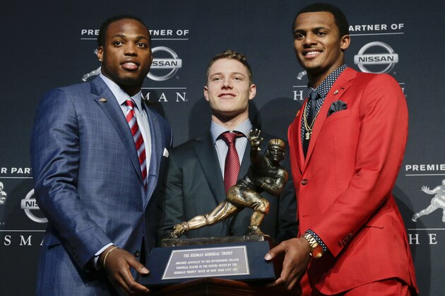 Heisman Trophy finalists, from left, Alabama's Derrick Henry, Stanford's Christian McCaffrey and Clemson's Deshaun Watson pose for a photo with the Heisman Trophy before the start of the award presentation show, Saturday, Dec. 12, 2015, in New York. (AP Photo/Julie Jacobson)