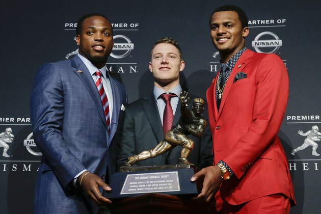 Heisman Trophy finalists, from left, Alabama's Derrick Henry, Stanford's Christian McCaffrey and Clemson's Deshaun Watson pose for a photo with the Heisman Trophy before the start of the award presentation show, Saturday, Dec. 12, 2015, in New York. (AP Photo/Julie Jacobson)