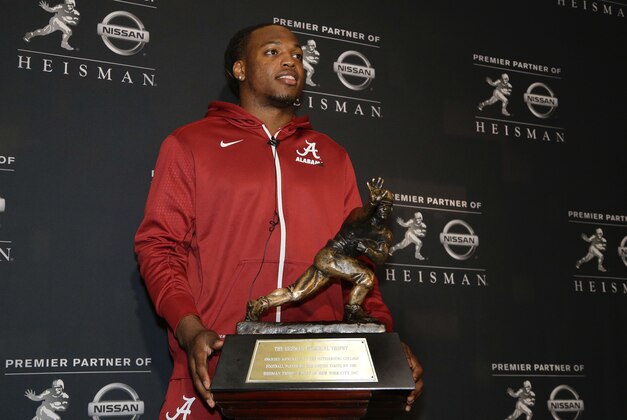 Alabama's Derrick Henry poses for photos with the Heisman Trophy, Friday, Dec. 11, 2015, in New York. Henry, along with Clemson's Deshaun Watson and Stanford's Christian McCaffrey, is a finalist for the trophy which recognizes college football's best player of the year. (AP Photo/Julie Jacobson)